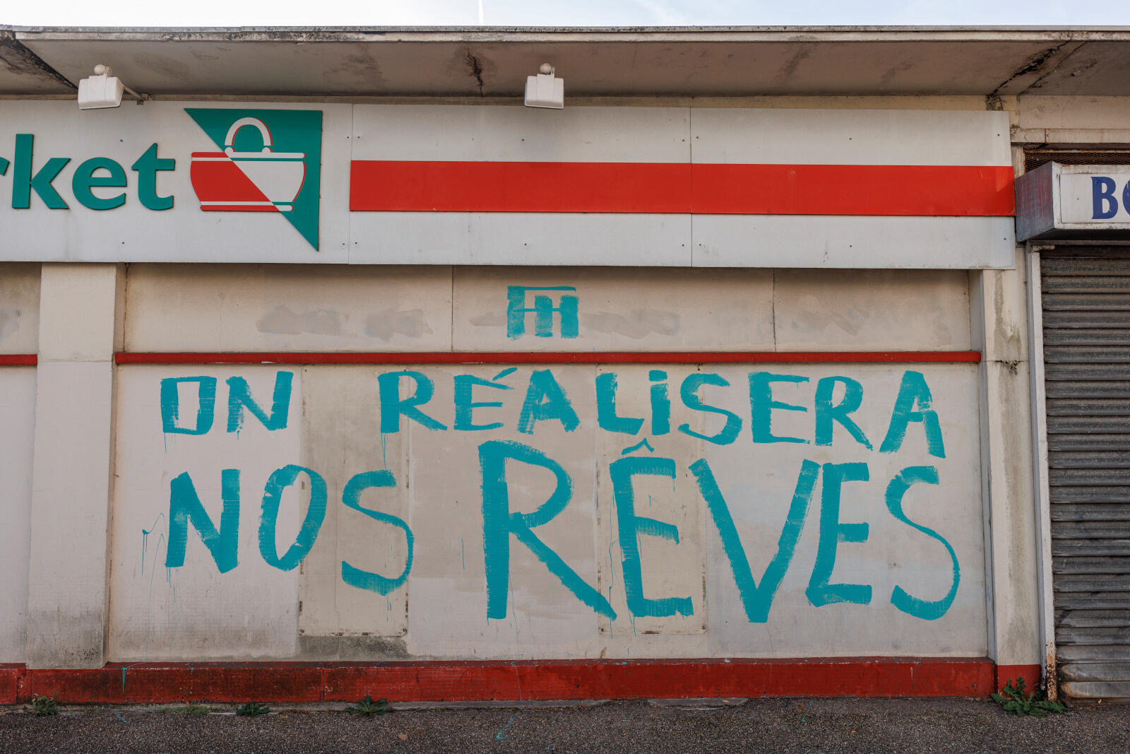 Une porte close avec la mention "ici on réalisera nos rêves"
